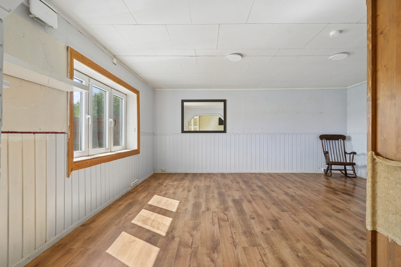Lys stue med utsyn mot eiendommens omgivelser. Galleribilde