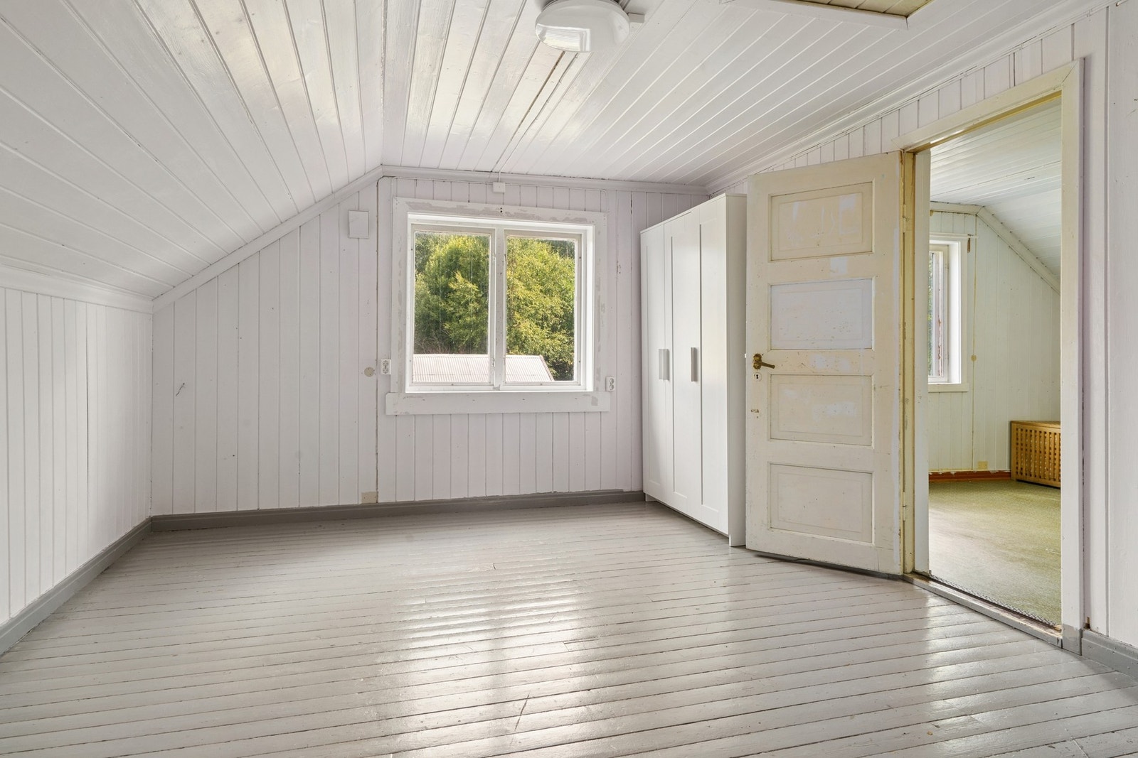 Lyst soverom med skråtak og vindu som gir godt naturlig lysinnslipp. Galleribilde