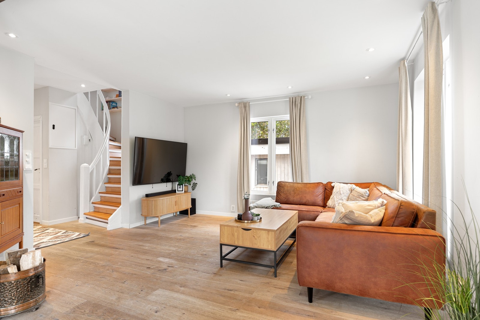 Lys, romslig stue med downlights i tak og store vindusflater. Galleribilde