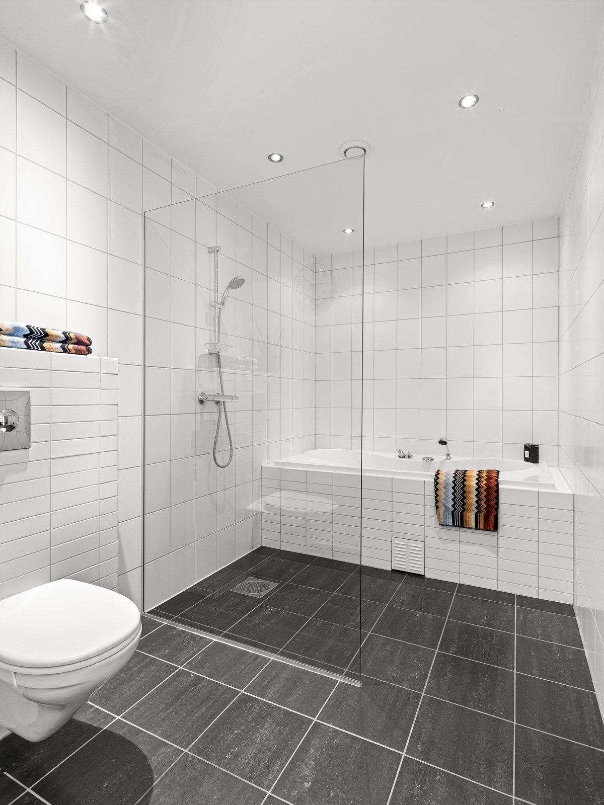 Rommet er utstyrt med både badekar og dusjvegg. Vegghengt wc. Galleribilde
