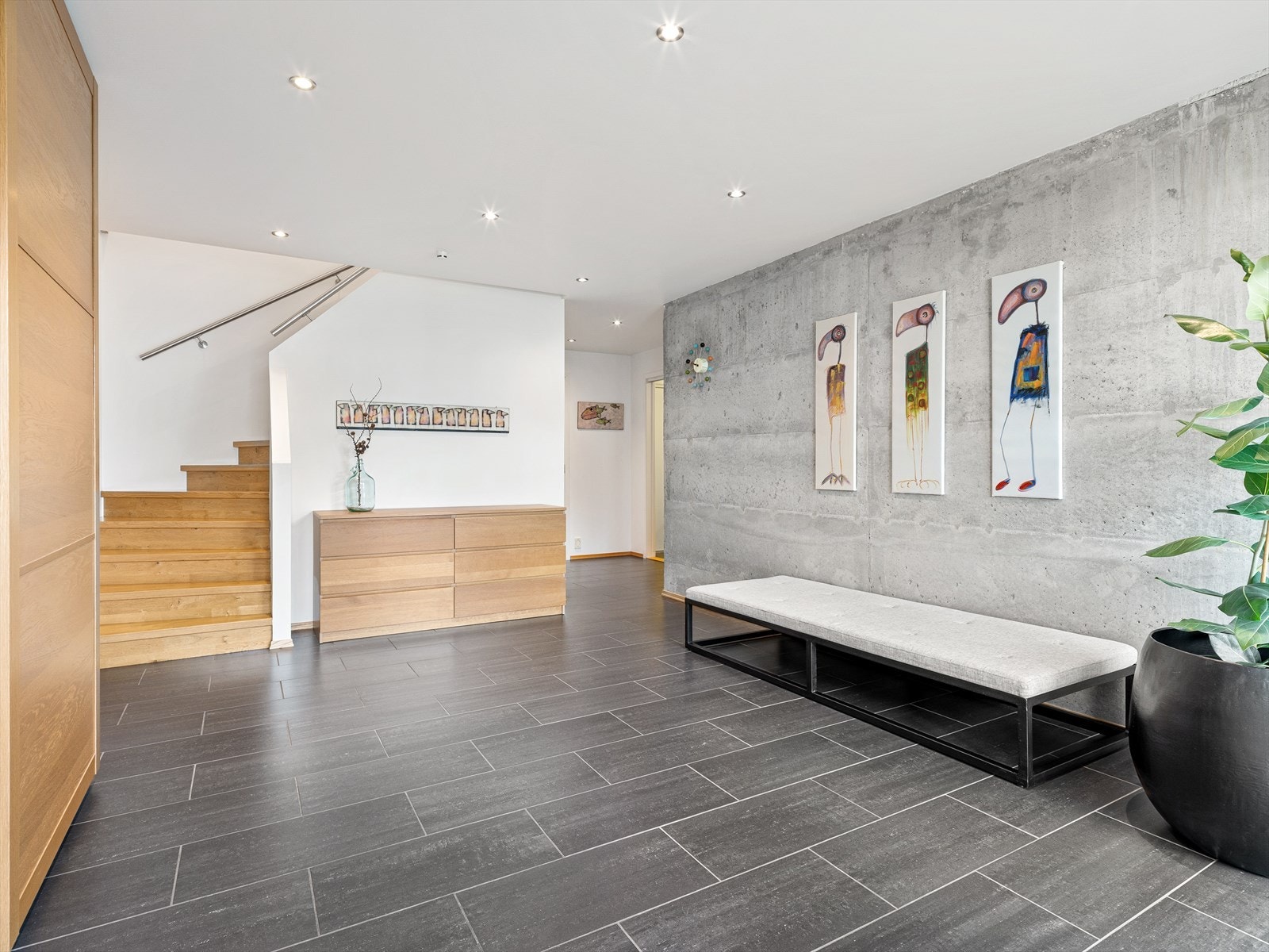 Flislagt gulv og en eksponert betongvegg. Spotter i tak. Galleribilde