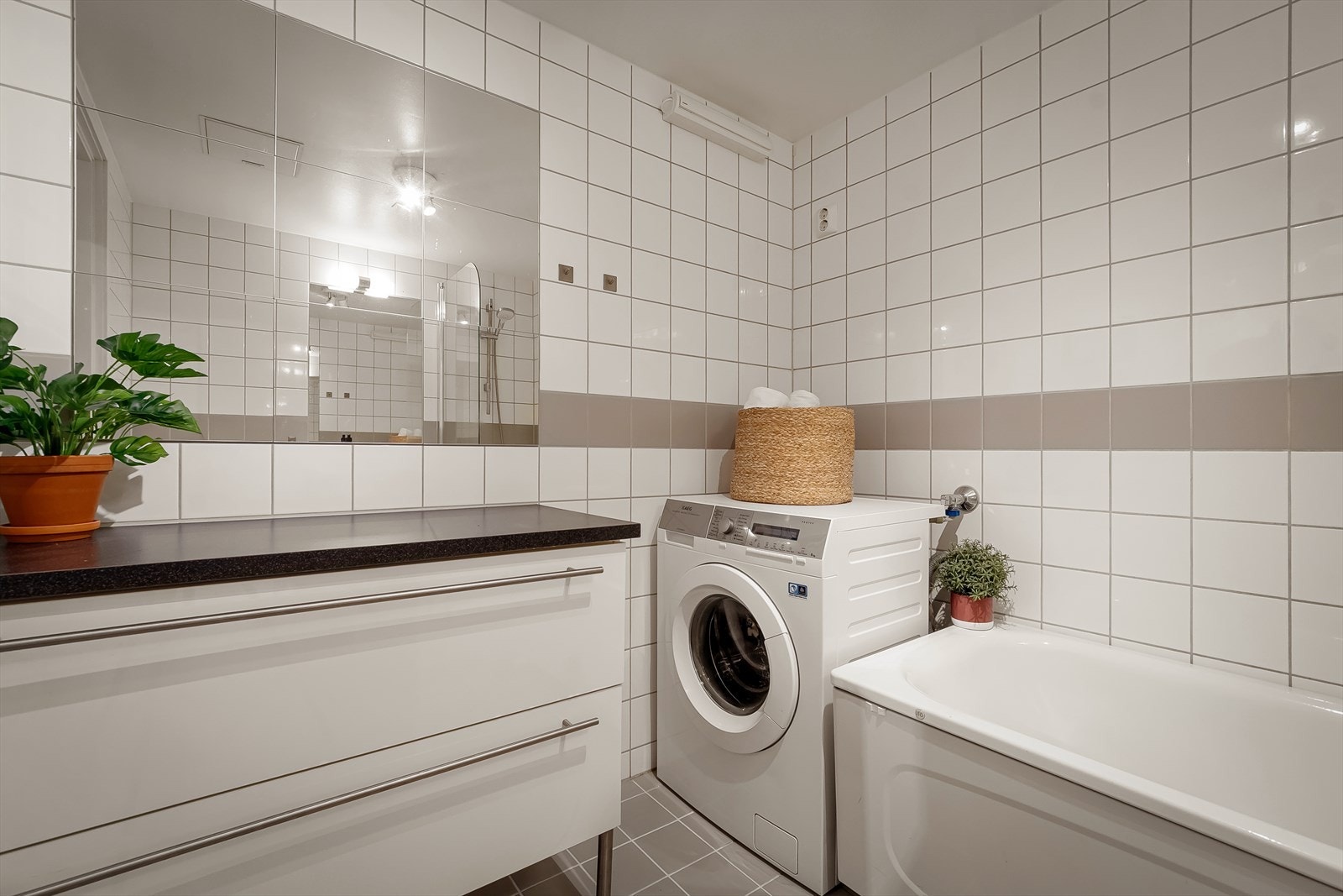 Badet er utstyrt med badekar med tappekran og dusjslange, opplegg for vaskemaskin, servant og gulvstående toalett. Galleribilde