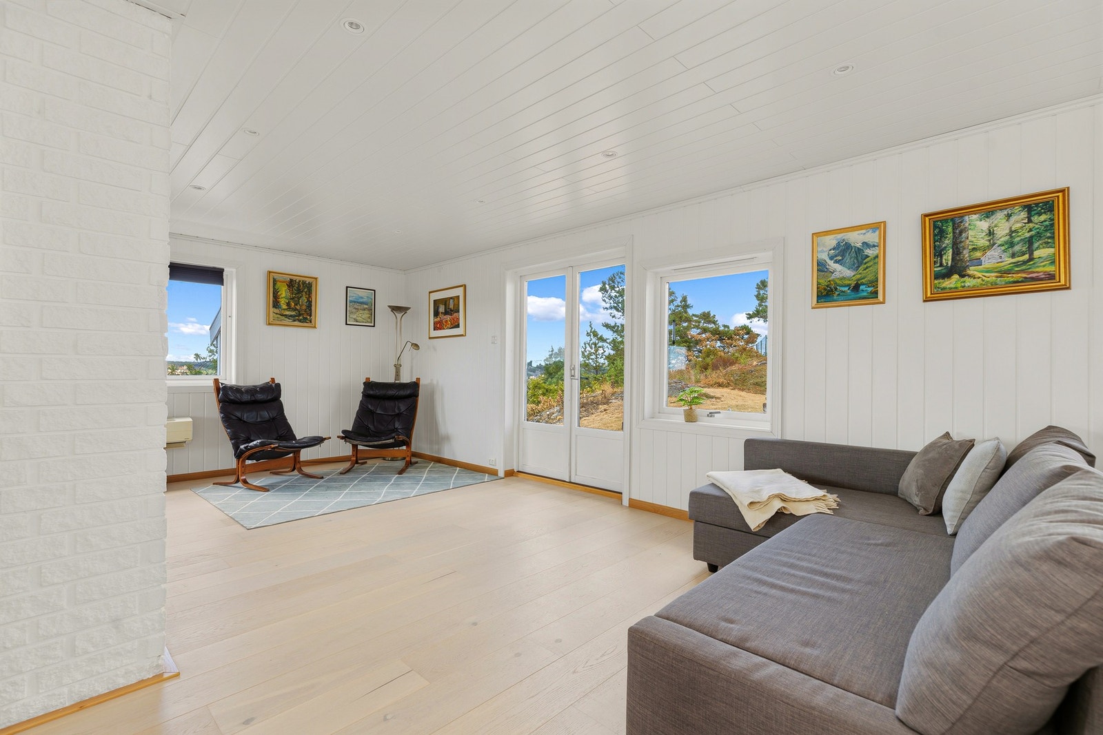 Romslig stue med store vindusflater som slipper inn rikelig med naturlig lys. Galleribilde
