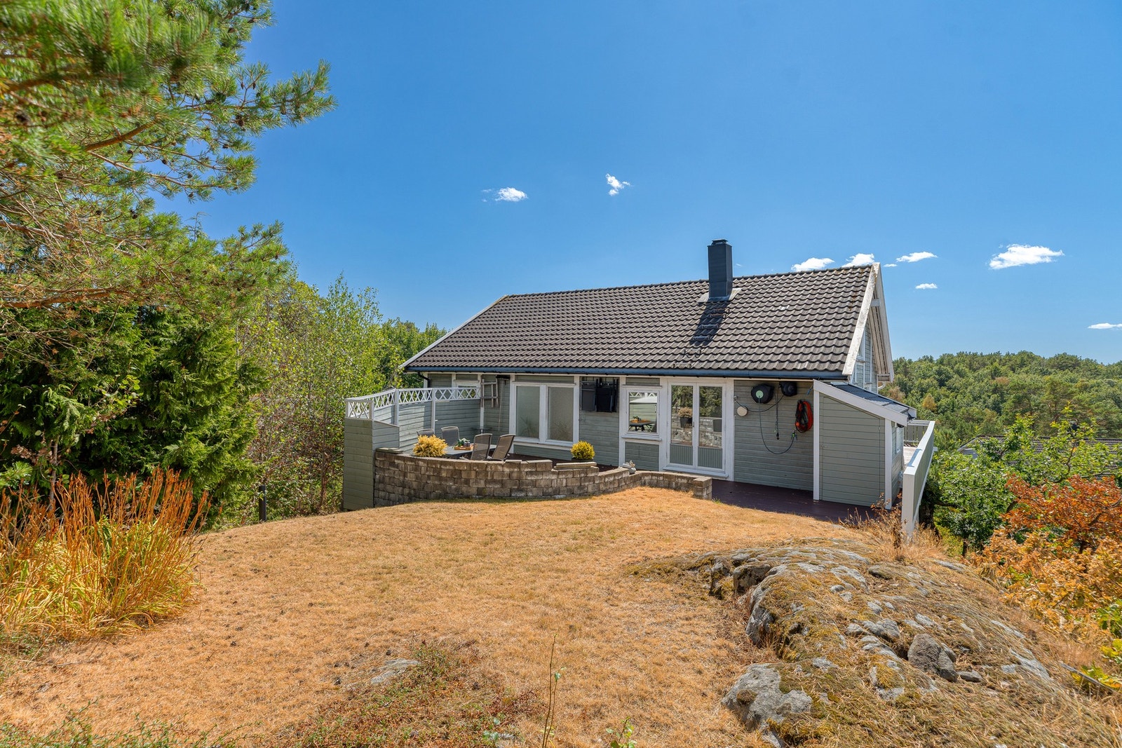 Den solrike hagen er opparbeidet med terrasse, plen og naturtomt med fjellknauser. Galleribilde
