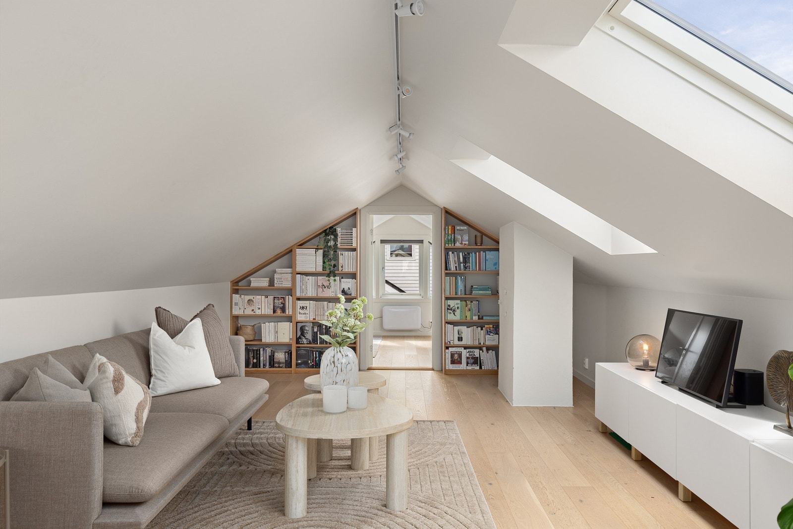 Lys og fin loftstue med plass til sittegruppe, tv-benk + tv, samt lesestol og/eller barneleker. Plassbygde bokhyller på vegg inn mot soverom. Galleribilde
