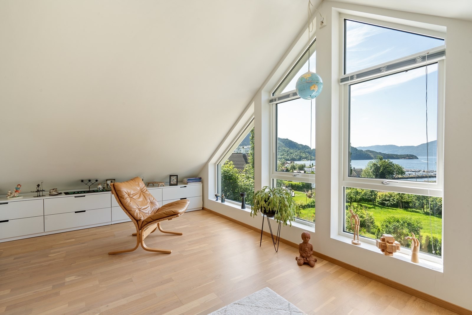 Lys og romslig loftstue med flere møbleringsmuligheter og store vinduer som slipper inn rikelig med dagslys. Galleribilde