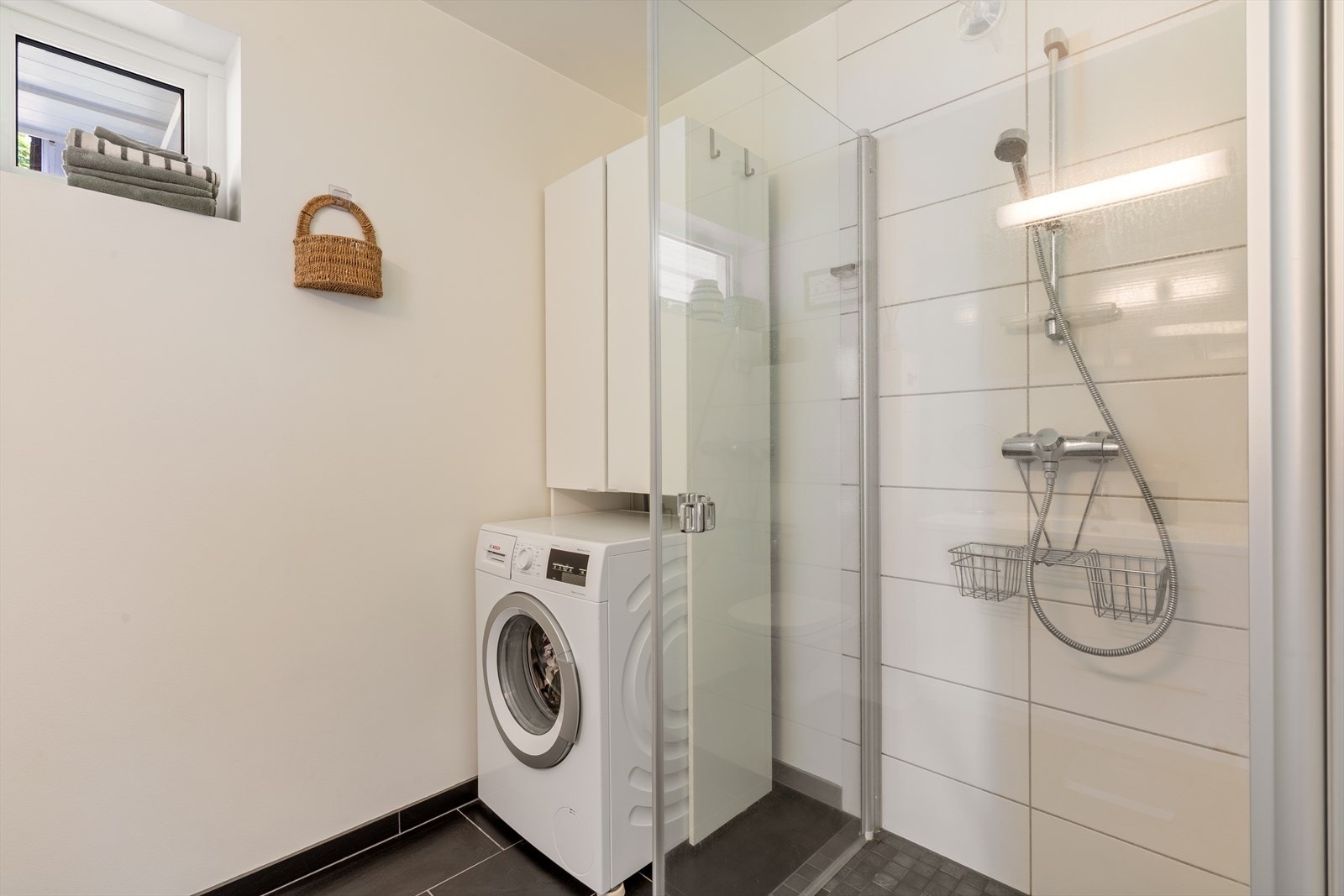 Badet er praktisk innredet med dusjhjørne og opplegg for vaskemaskin. Galleribilde