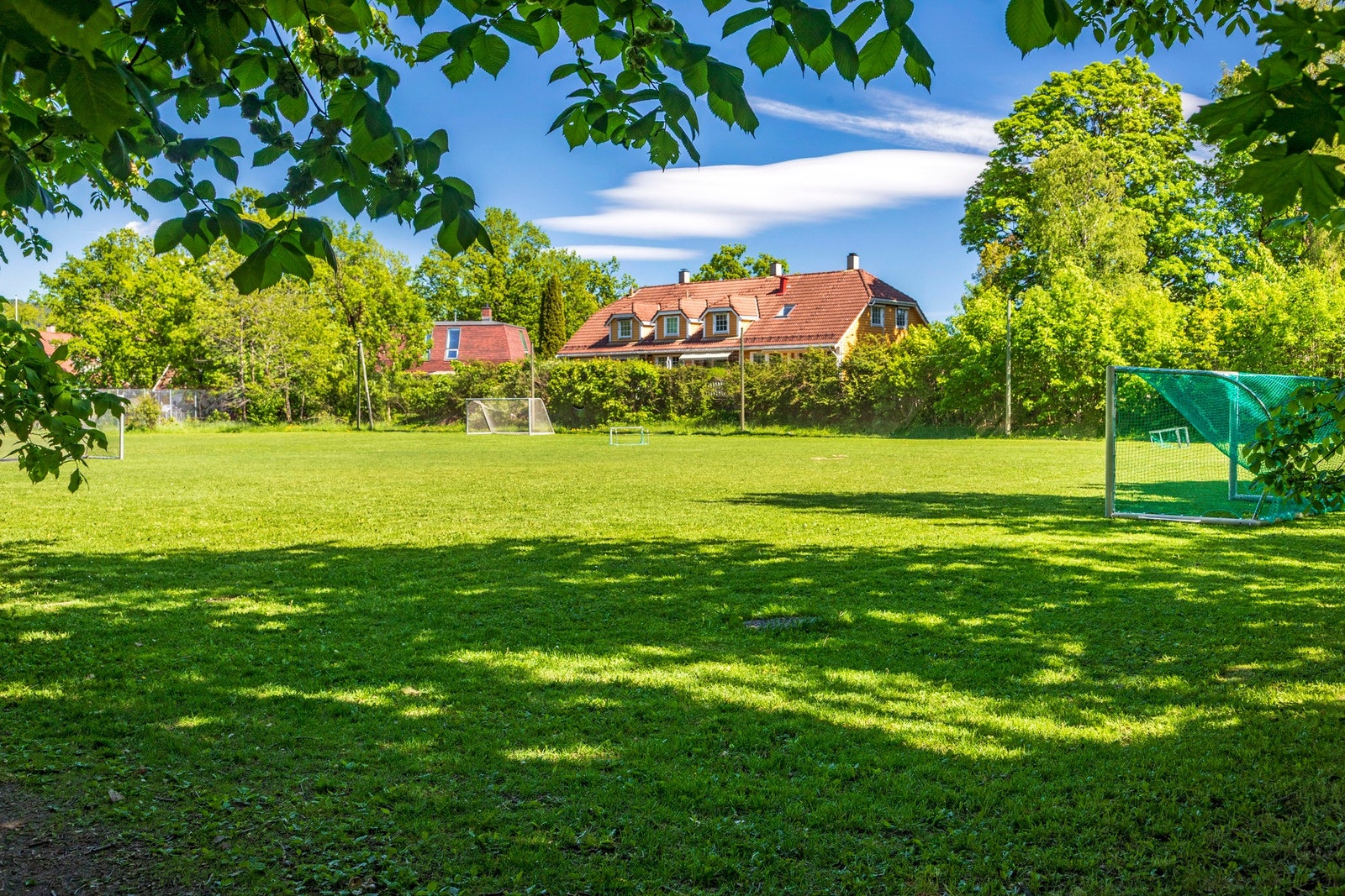 Eiendommen grenser til et friområde med fotballbane og tennisbaner, noe som gir en unik kombinasjon av privatliv og nærhet til aktivitetsmuligheter for hele familien. Galleribilde