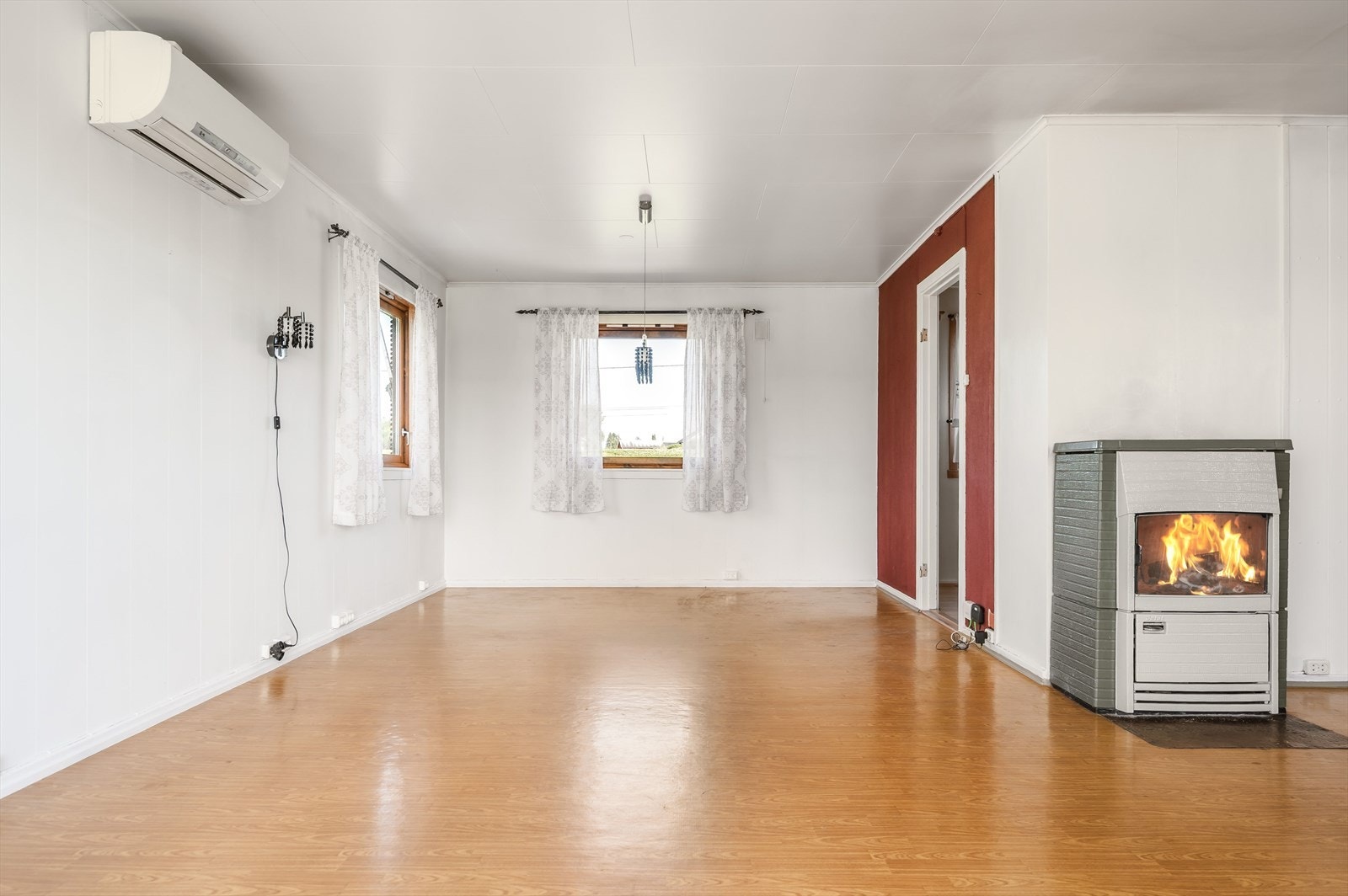 Stuen er lys og møbleringsvennlig, har varmepumpe og kombinert kamin og åpent ildsted. Galleribilde