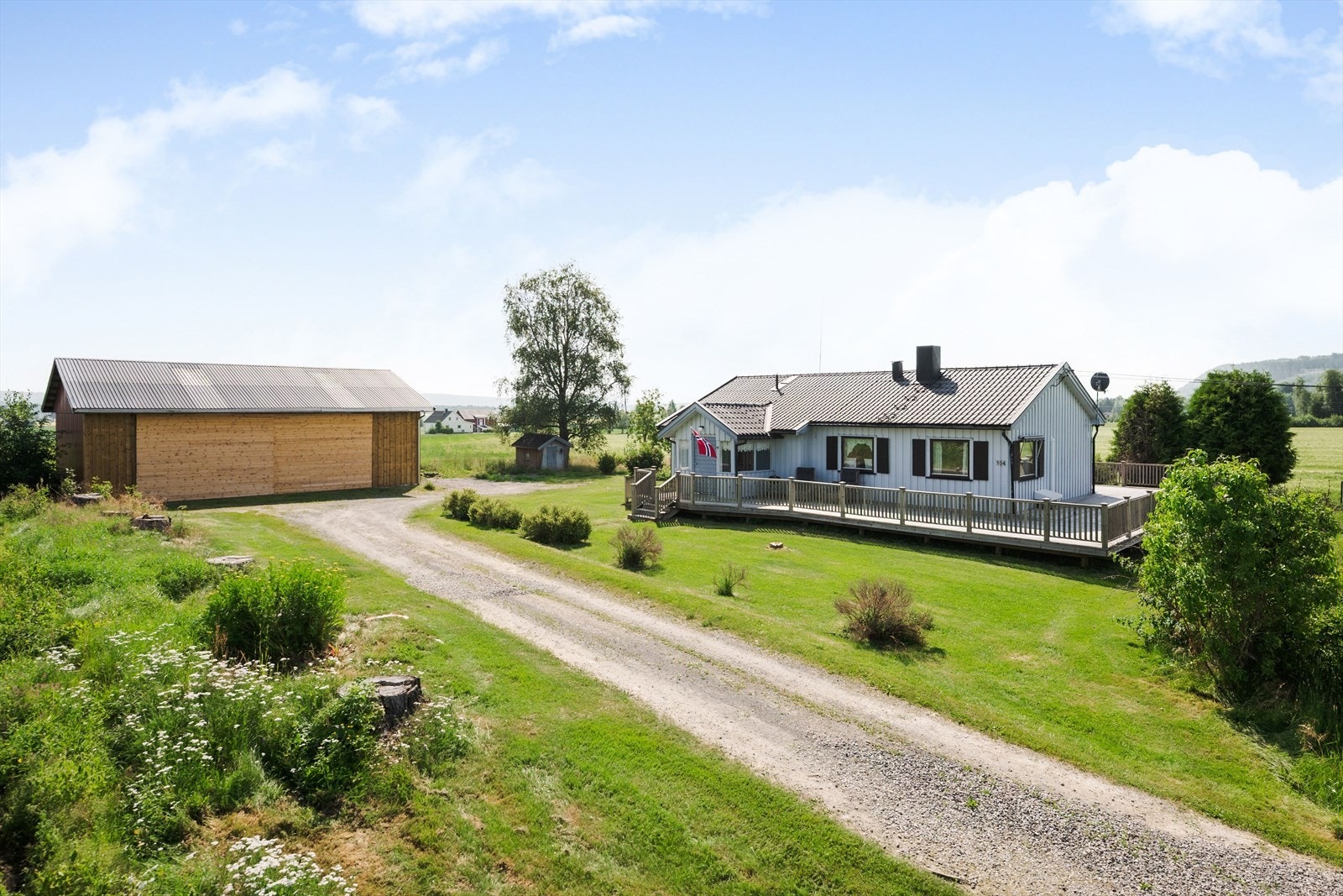 Koselig og pent opparbeidet tomt på ca. 1 612,7 m² med hage og beplantning og bebygd med enebolig, dukkestue/bod og driftsbygning. Galleribilde
