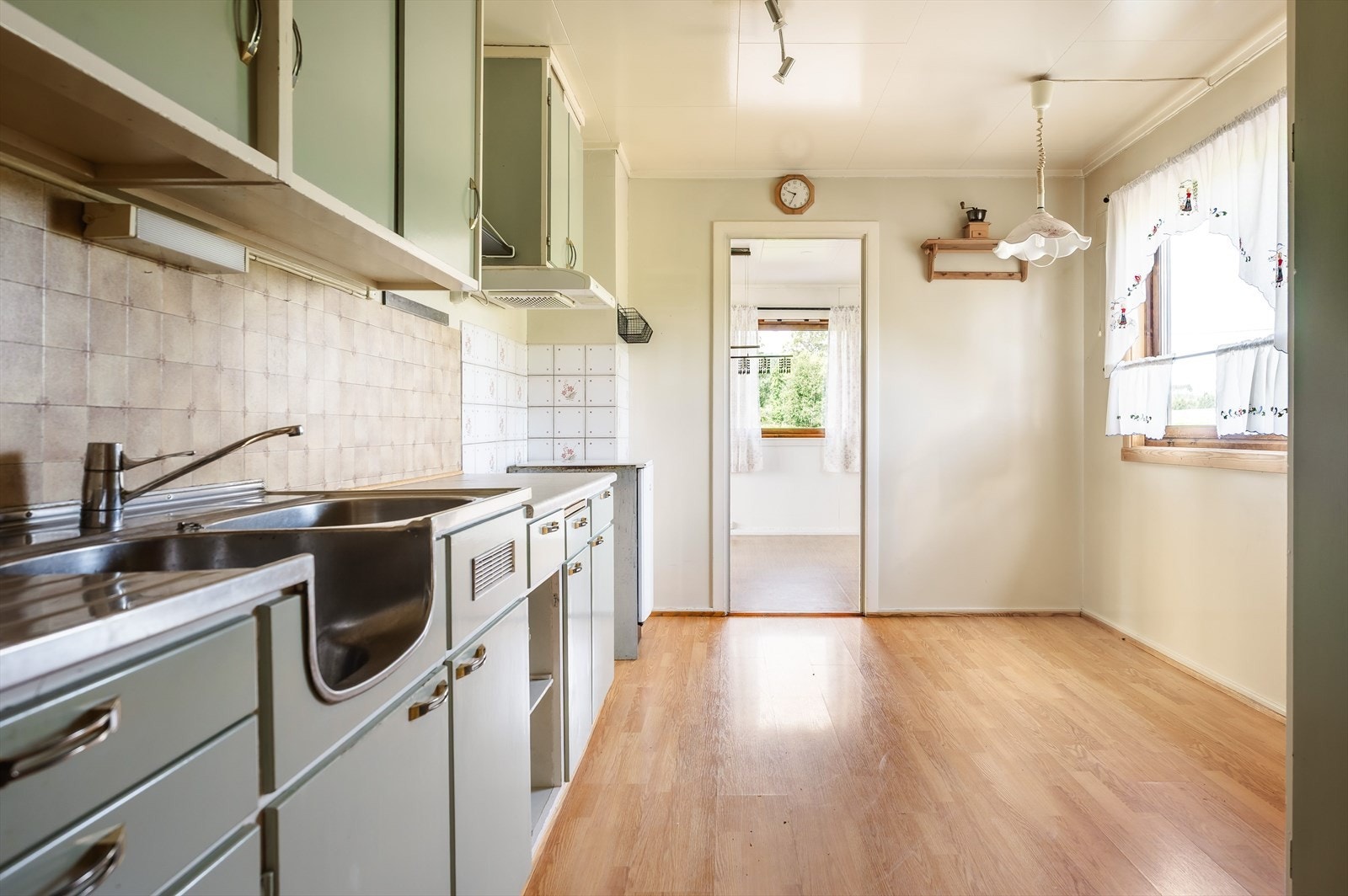 Det er overskap over innredning. Det er våtromstapet over benkeplate, og flislagt nedre del av vegg ved avsatt plass til komfyr. Det er plass til kjøleskap i rommet, og tre høyskap på
yttervegg. Galleribilde