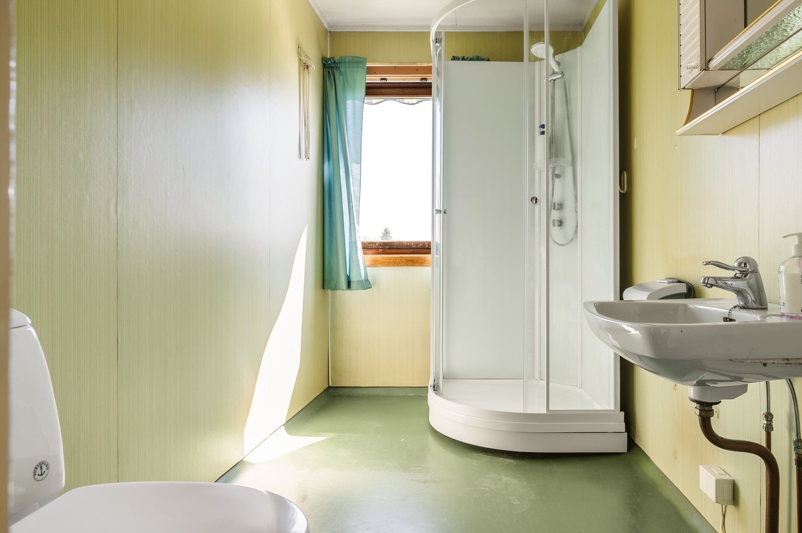 Det har toalett, servant med speilskap, dusjkabinett fra de senere år og naturlig ventilasjon via vindusventil med tilluft fra spalte under døra. Galleribilde