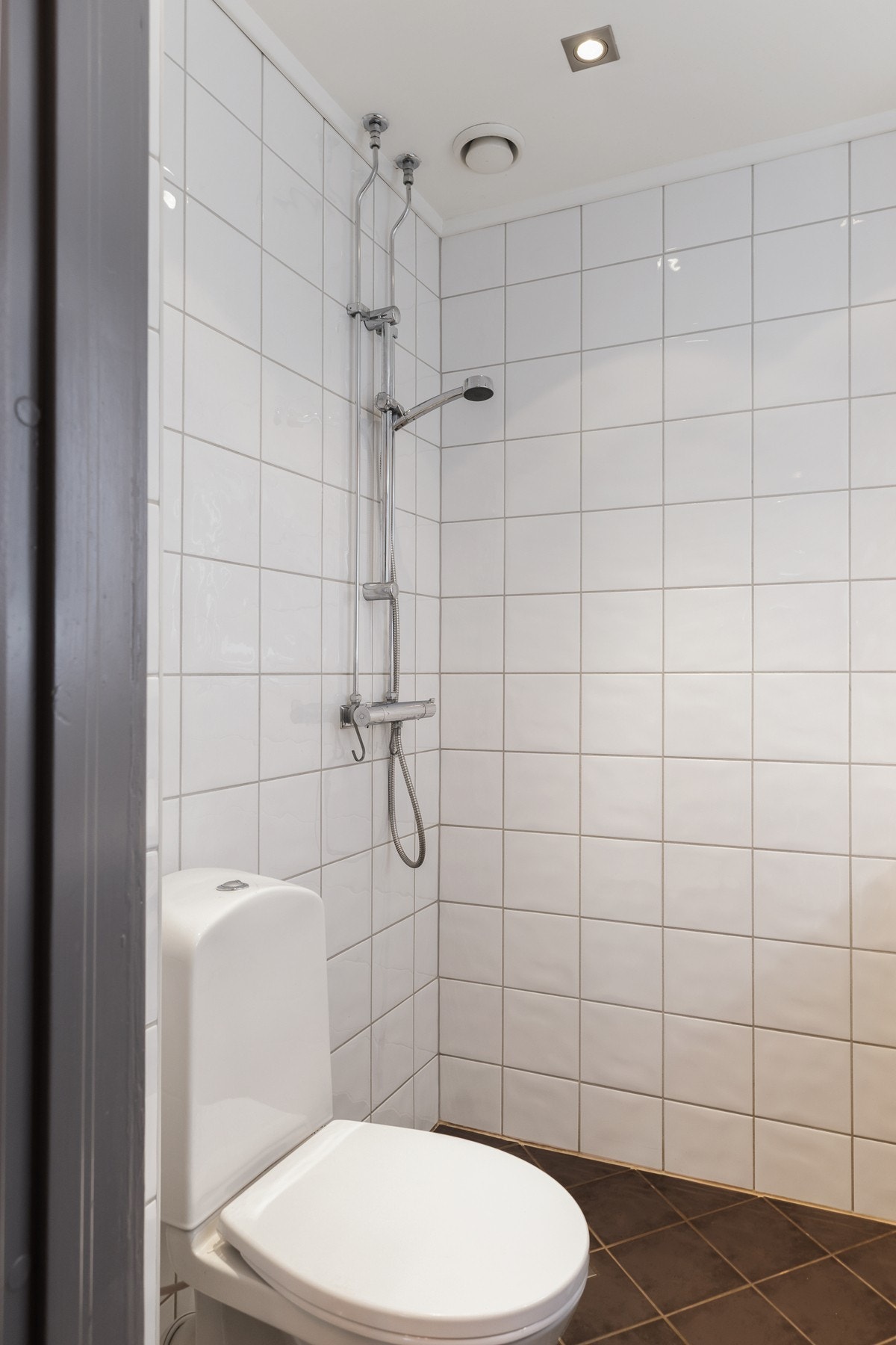 Badet er innredet med dusjhjørne, servant med baderomsinnredning, speil, gulvstående toalett og opplegg for vaskemaskin Galleribilde