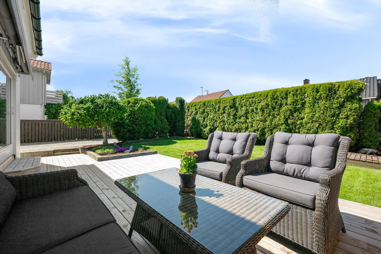 På fremsiden av boligen er det en pen opparbeidet hage med gressplen, terrasse og fin beplantning. Hekk langs tomtegrensen gir god avskjerming. Galleribilde