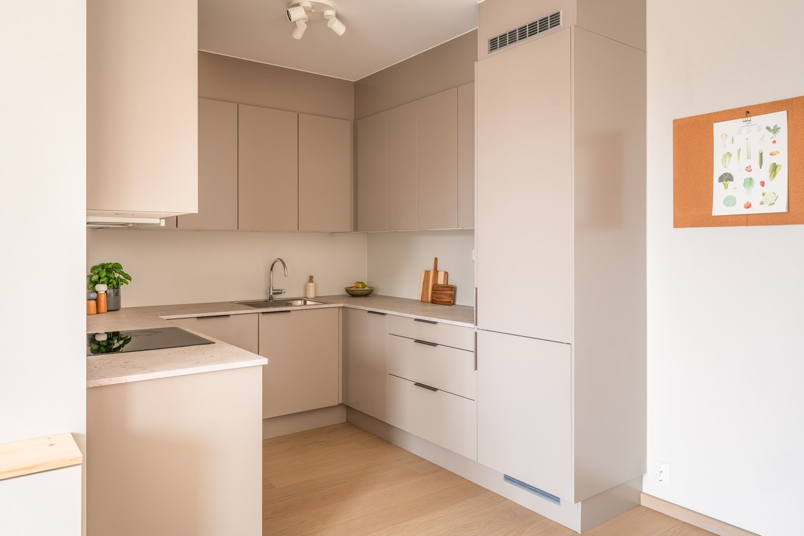 Kjøkkeninnredningen har stilrene, glatte fronter og laminat benkeplate med nedfelt oppvaskkum og ett-greps svingbart blandebatteri. Galleribilde
