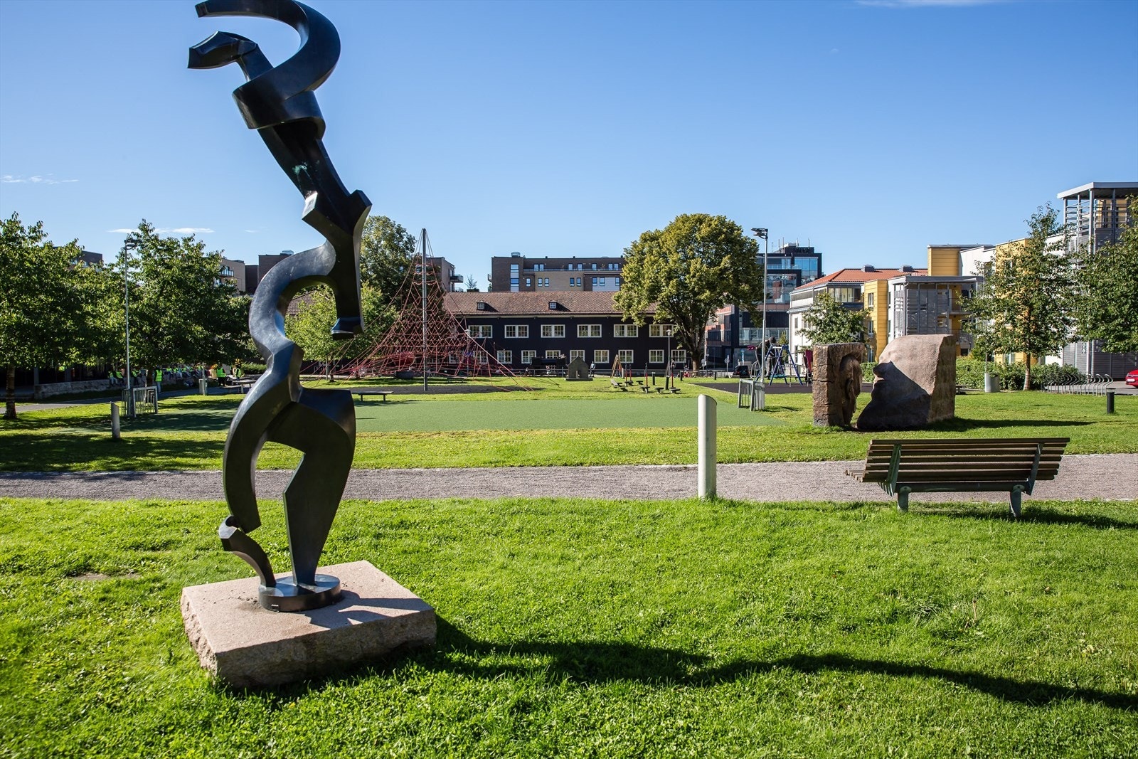 En solfylt dag i Lørenparken, hvor grønne plener og moderne skulpturer skaper en fredelig oase midt i Oslo. Galleribilde