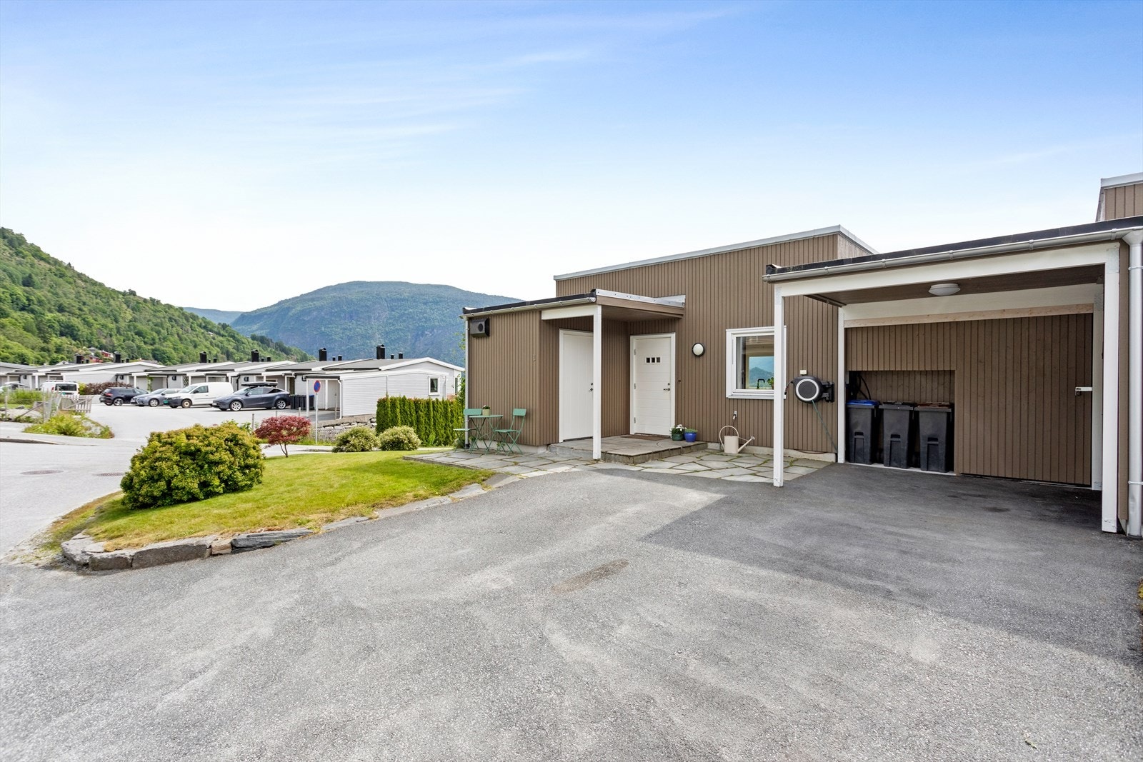 Bustaden har flott opparbeid og forseggjort uteområde med plen og asfaltert tun. Her er det også carport der del av carport er innreda som bod. Sportsbod like ved inngangen. Galleribilde