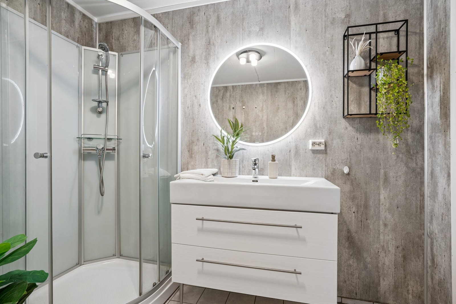 Badet er utstyrt med dusjkabinett, servantinnredning og speil med belysning. Galleribilde