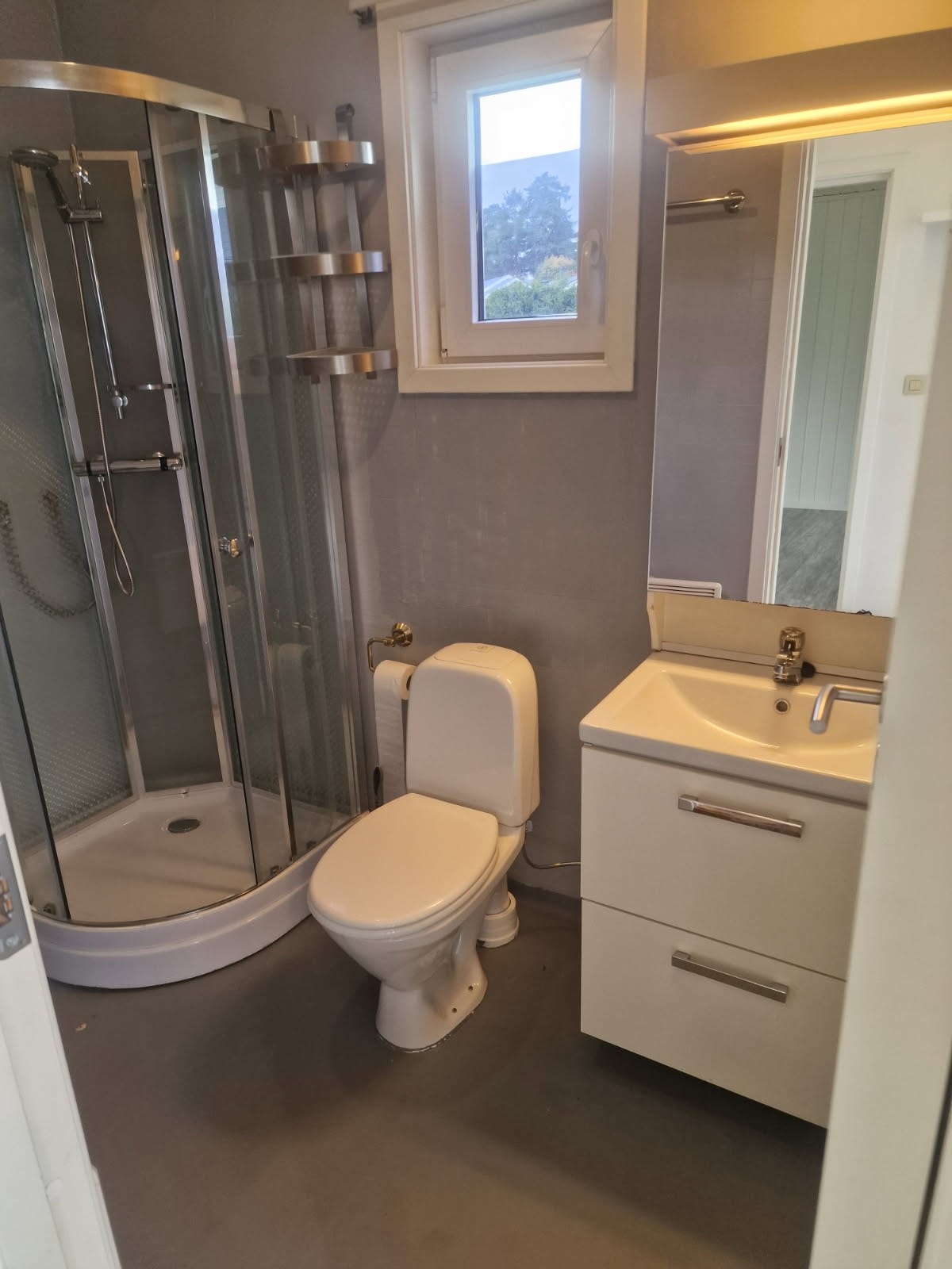Bad i leiligheten. Gulv med vinylbelegg og vegger med baderomstapet. Servant på
skap med hvite glatte fronter. Gulvstående wc. Dusjkabinett.
Opplegg for vaskemaskin. Selgers bilde. Galleribilde