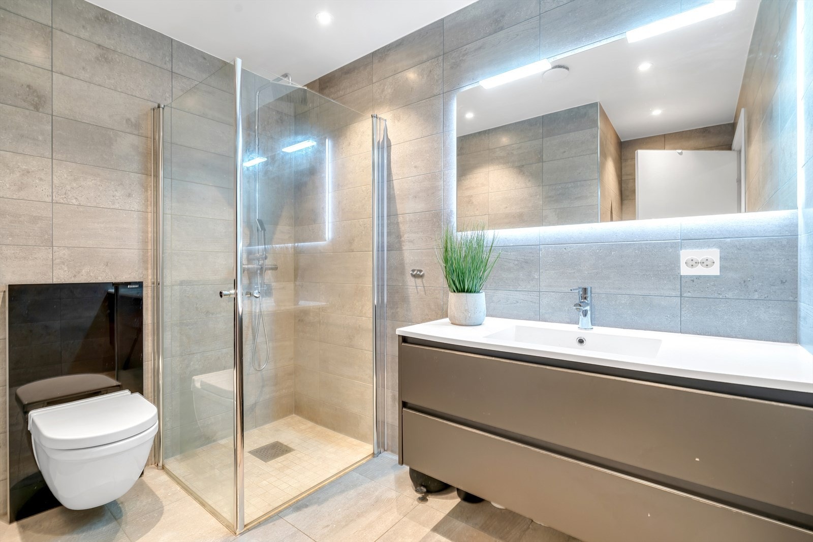 Tilknyttet hovedboligen finner du dette lekre badet, med delikat dusjnisje, vegghengt toalett og praktisk baderomsinnredning. Galleribilde