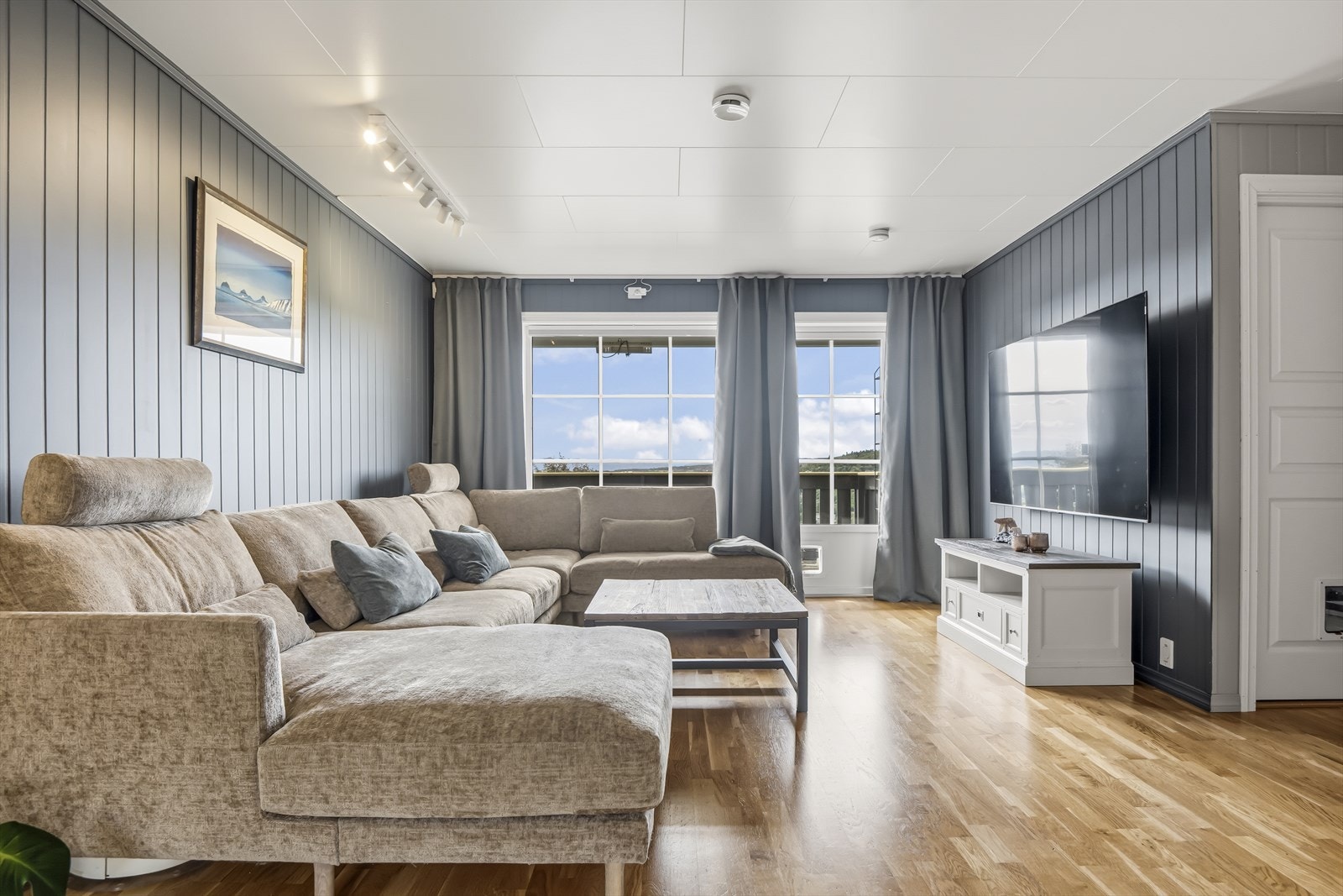 Lys og romslig stue med store vindusflater som slipper inn rikelig med dagslys. Galleribilde