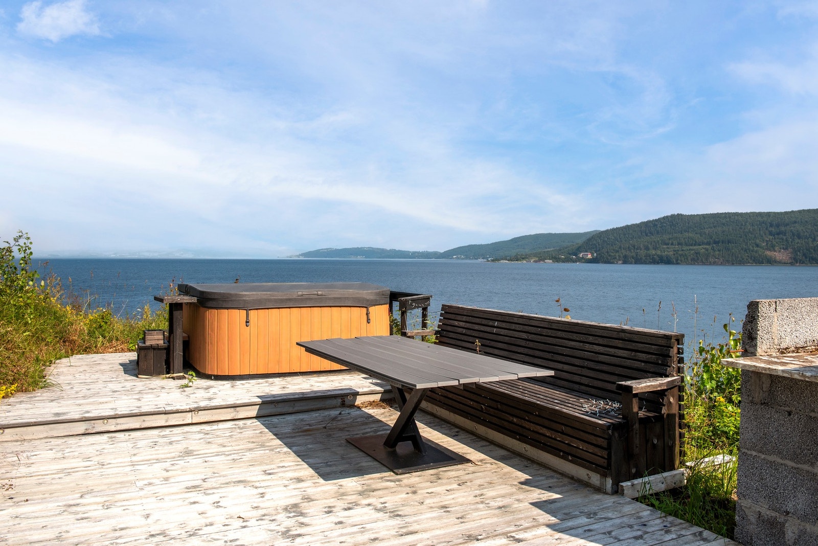 Solrik uteplass med sittebenk, utepeis og jacuzzi. Galleribilde