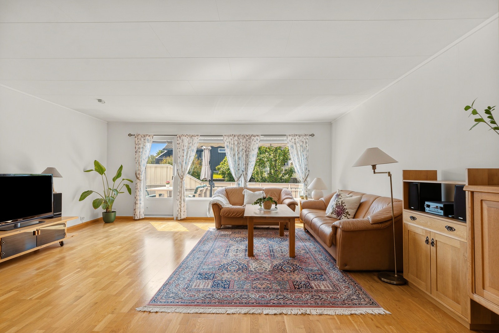 Den romslige stuen har store vindusflater som slipper inn rikelig med dagslys. Galleribilde