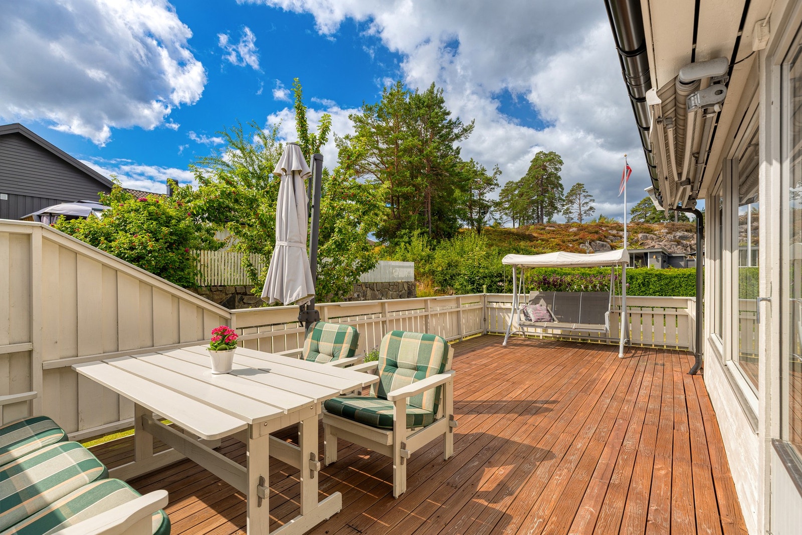 Boligen har en stor og solrik terrasse - en naturlig forlengelse av stuen med god plass til hyggelige måltider og avslappende sommerdager. Galleribilde