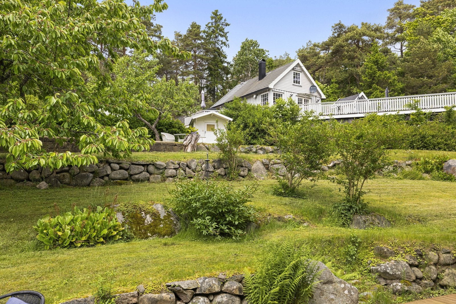 Utsikt over den store, grønne hagen fra terrassen. Galleribilde
