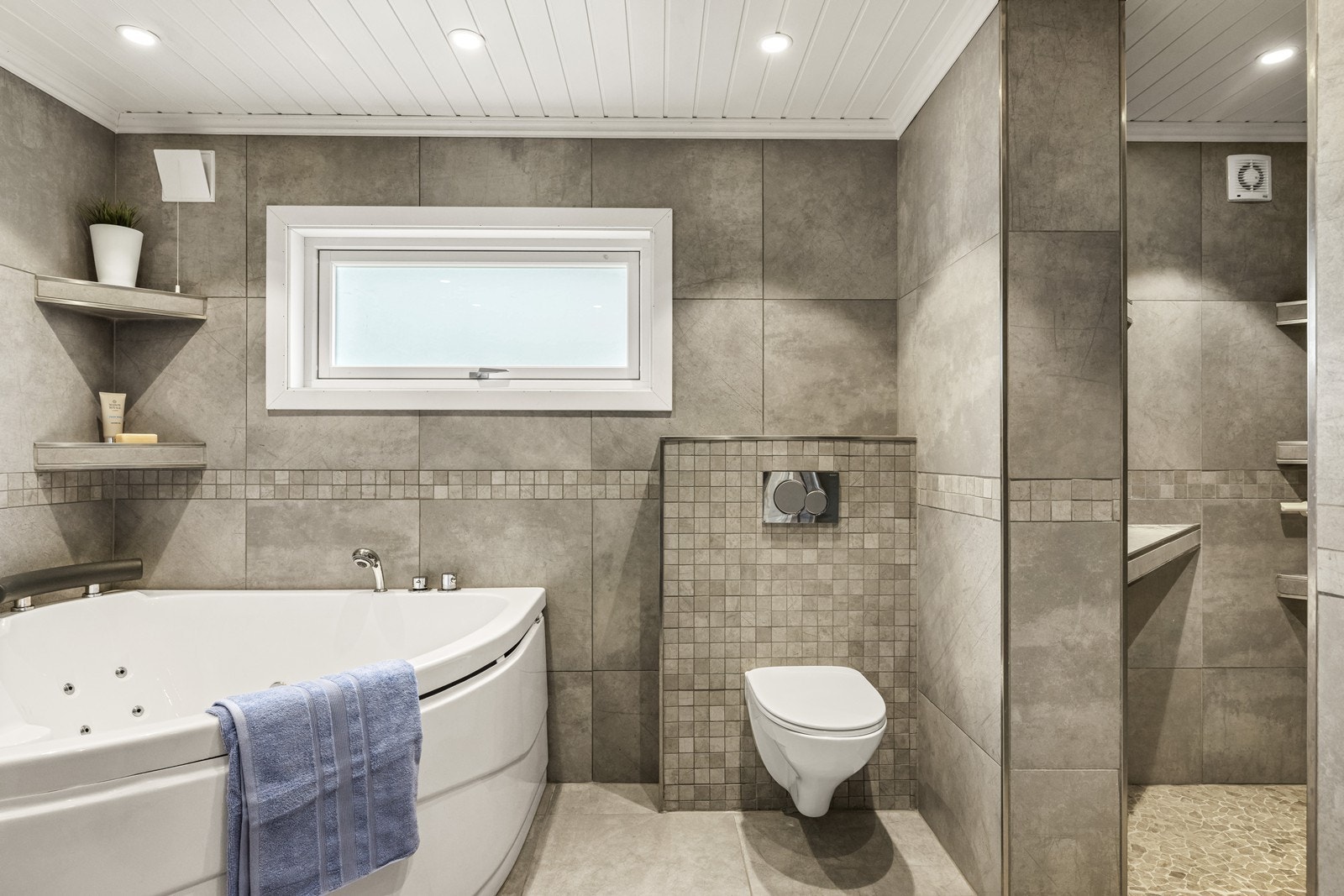 Badet er utstyrt med vegghengt toalett og har en egen dusjnisje i tillegg til badekaret. Galleribilde
