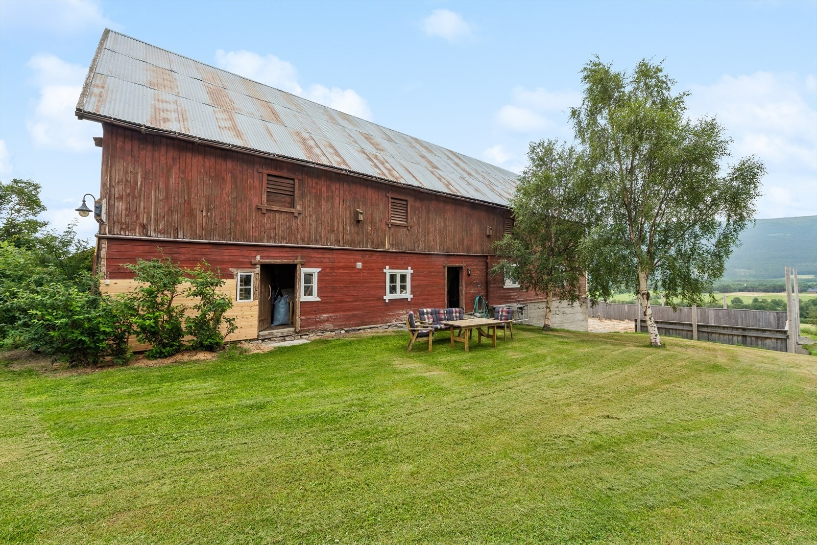 Eiendommen har store, grønne uteområder og et trivelig gårdstun. Galleribilde