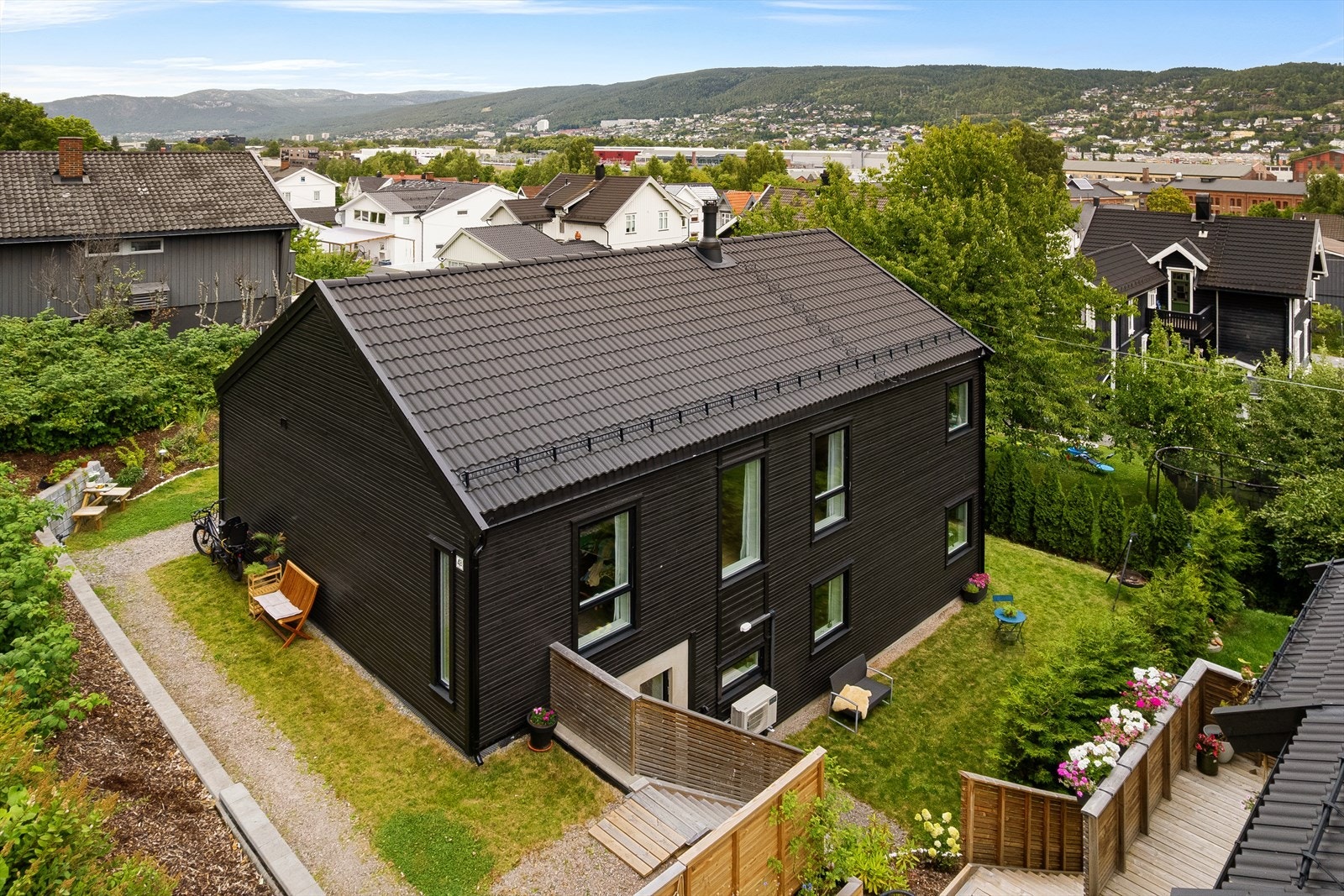 Tomten er pent opparbeidet med hage, støttemurer og diverse beplantning Galleribilde