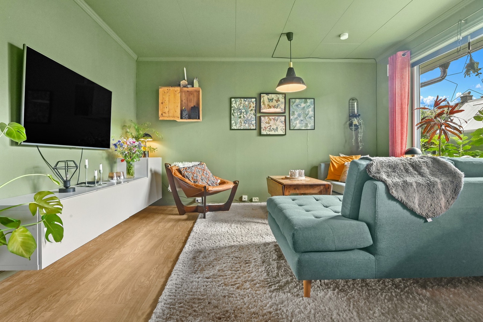 Lyst og innbydende rom med store vinduer og grønne vegger. Galleribilde
