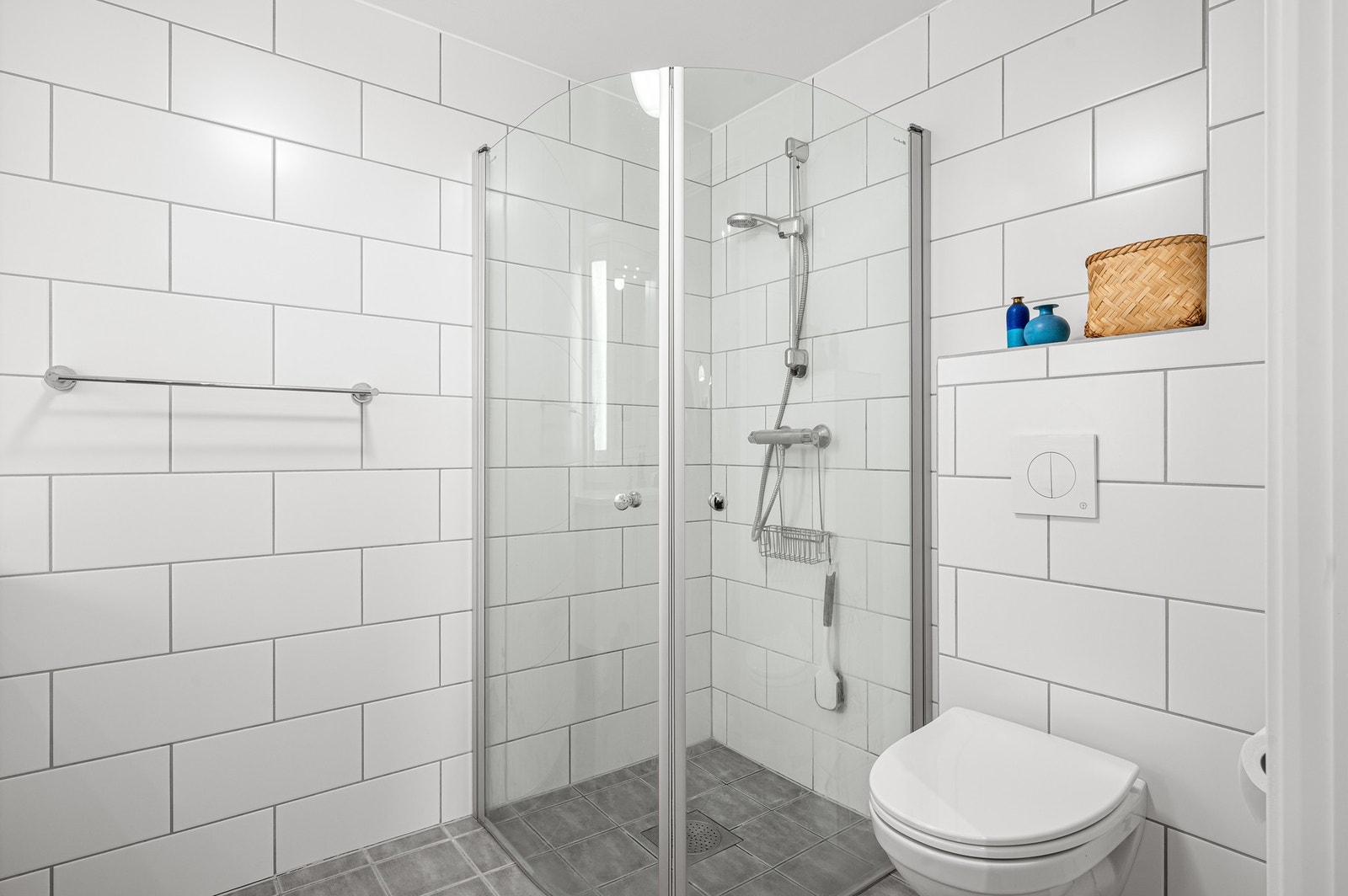 Badet er utstyrt med vegghengt toalett, dusjhjørne og vegghengt baderomsinnredning. Galleribilde