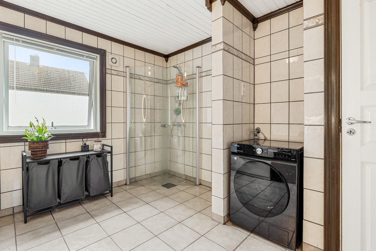 Badet er utstyrt med servant, toalett, badekar, dusjvegger/hjørne og opplegg for vaskemaskin Galleribilde