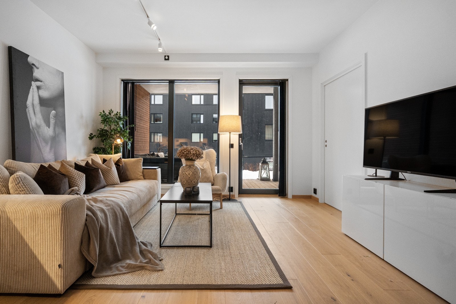 Lyst parkettgulv og malte vegger gir et moderne preg til stuen. Galleribilde