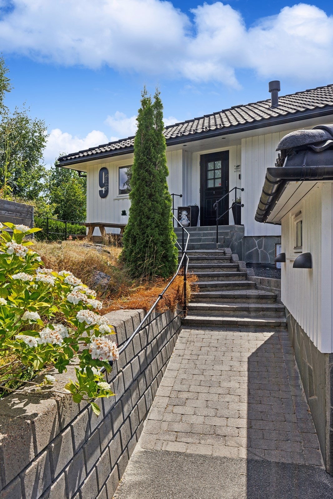Pent opparbeidet adkomst med belegningsstein og støttemur. Galleribilde