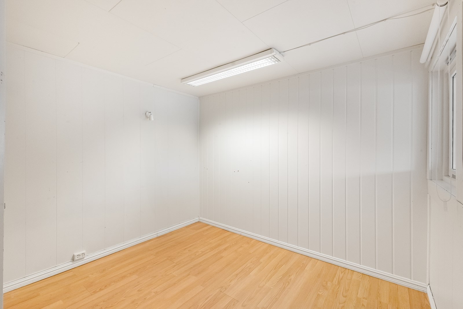 Soverom 1/oppholdsrom med egen inngang, har panelte veggflater og laminatgulv. Galleribilde