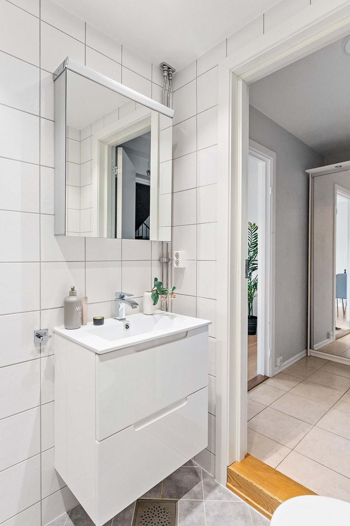 Badet har dusj, vegghengt toalett og servant med speil- og skuffeseksjon. Galleribilde