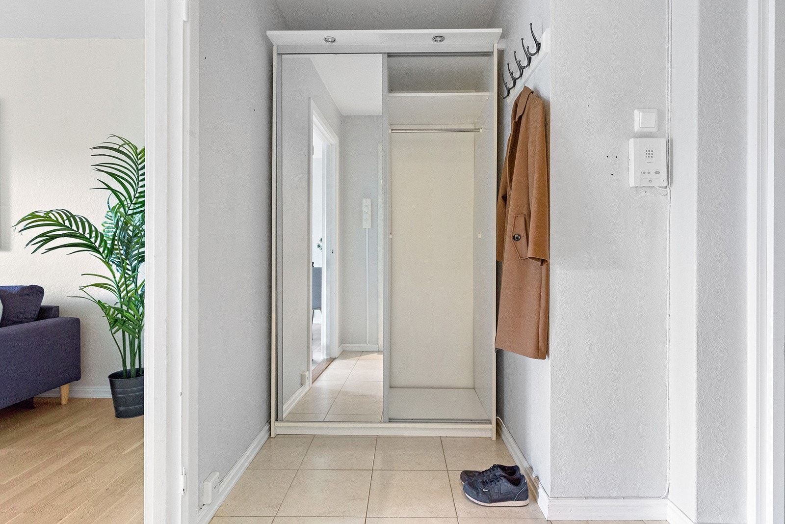 Lys og romslig entré med praktisk skyvedørsgarderobe, oppheng for yttertøy og varmekabler i gulv. Galleribilde
