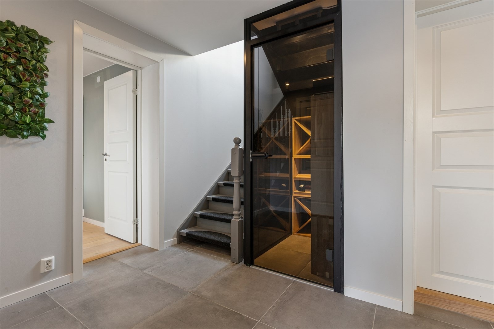 Integrert vinrom med glassdør i gangen, en eksklusiv løsning som kombinerer design og funksjonalitet. Galleribilde