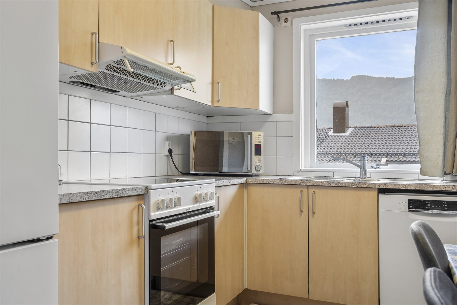 Praktisk kjøkken med ventilator og plass til spisebord. Galleribilde