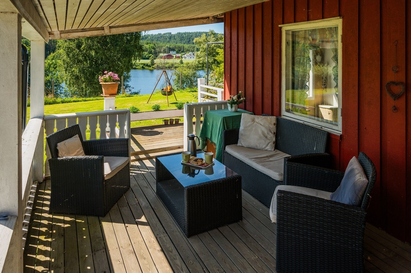 Deler av terrassen er overbygget. Det er terrassebord på gulv og rekkverk av malt treverk. Galleribilde