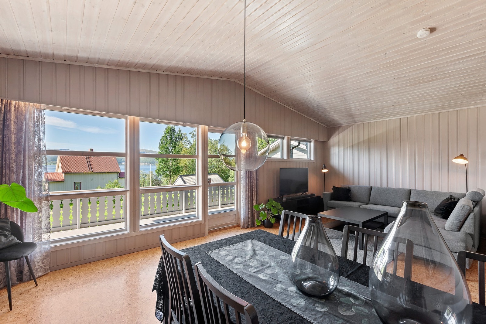 Stuen har god plass til både sofagruppe og spisebord, og store vinduer gir fin kontakt med uteområdet. Galleribilde