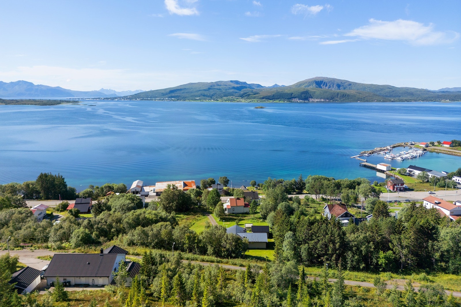 Oversiktsbilde som gir et godt inntrykk av beliggenheten mellom sjøen og fjellområdene. Galleribilde