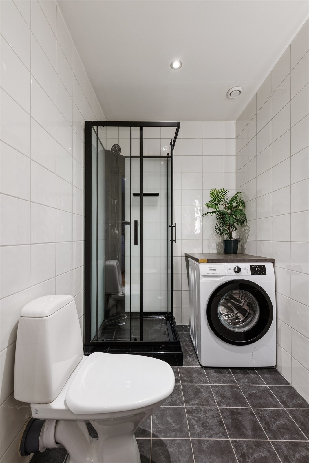 Badet har flislagte overflater og praktisk opplegg for vaskemaskin. Galleribilde