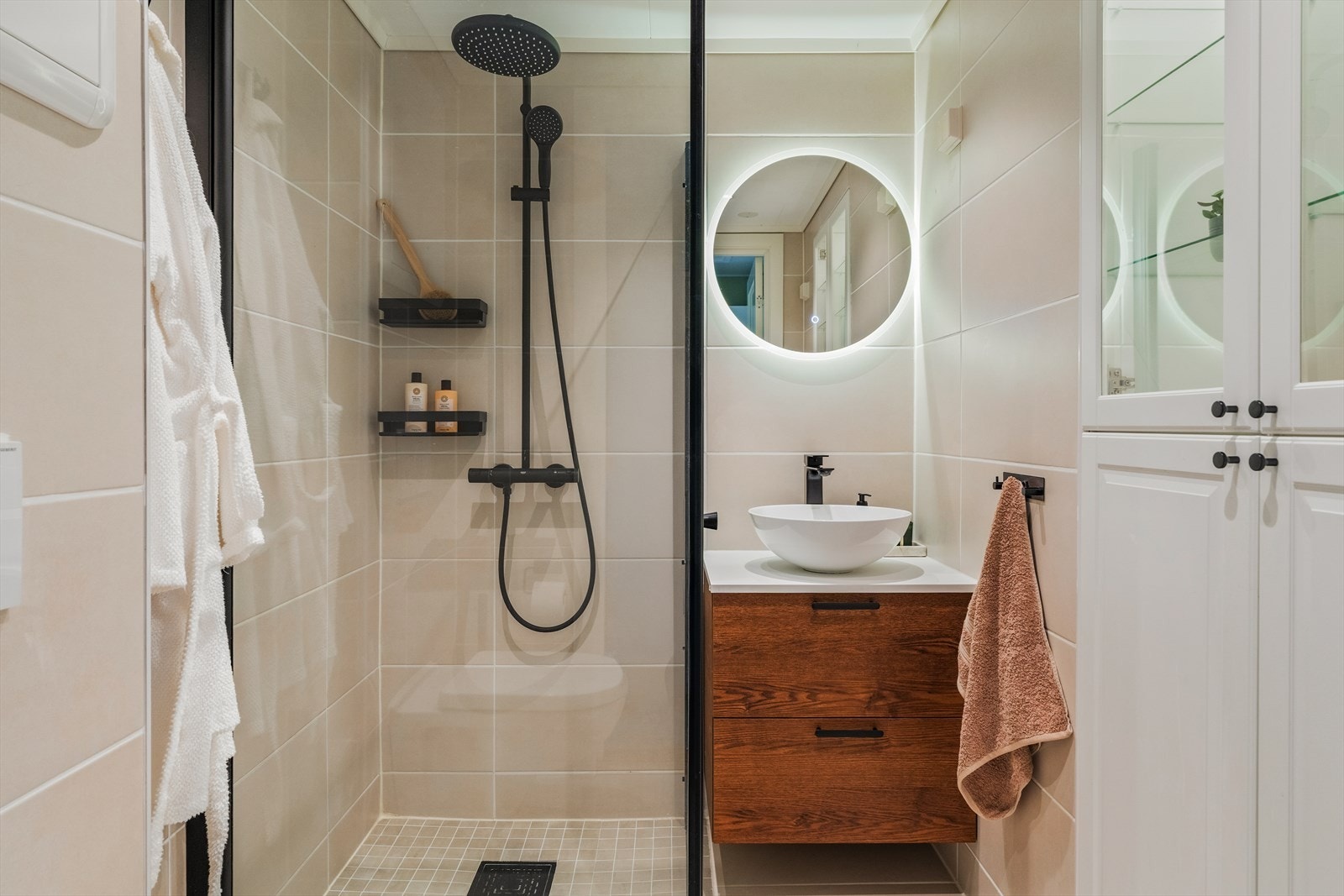 Badet ble renovert i 2022 og fremstår moderne med stilrene materialvalg og en gjennomført utførelse. Gulv og vegger er flislagt med keramiske fliser, mens himlingen har innfelte LED-spotter som gir et behagelig og godt lys. Galleribilde