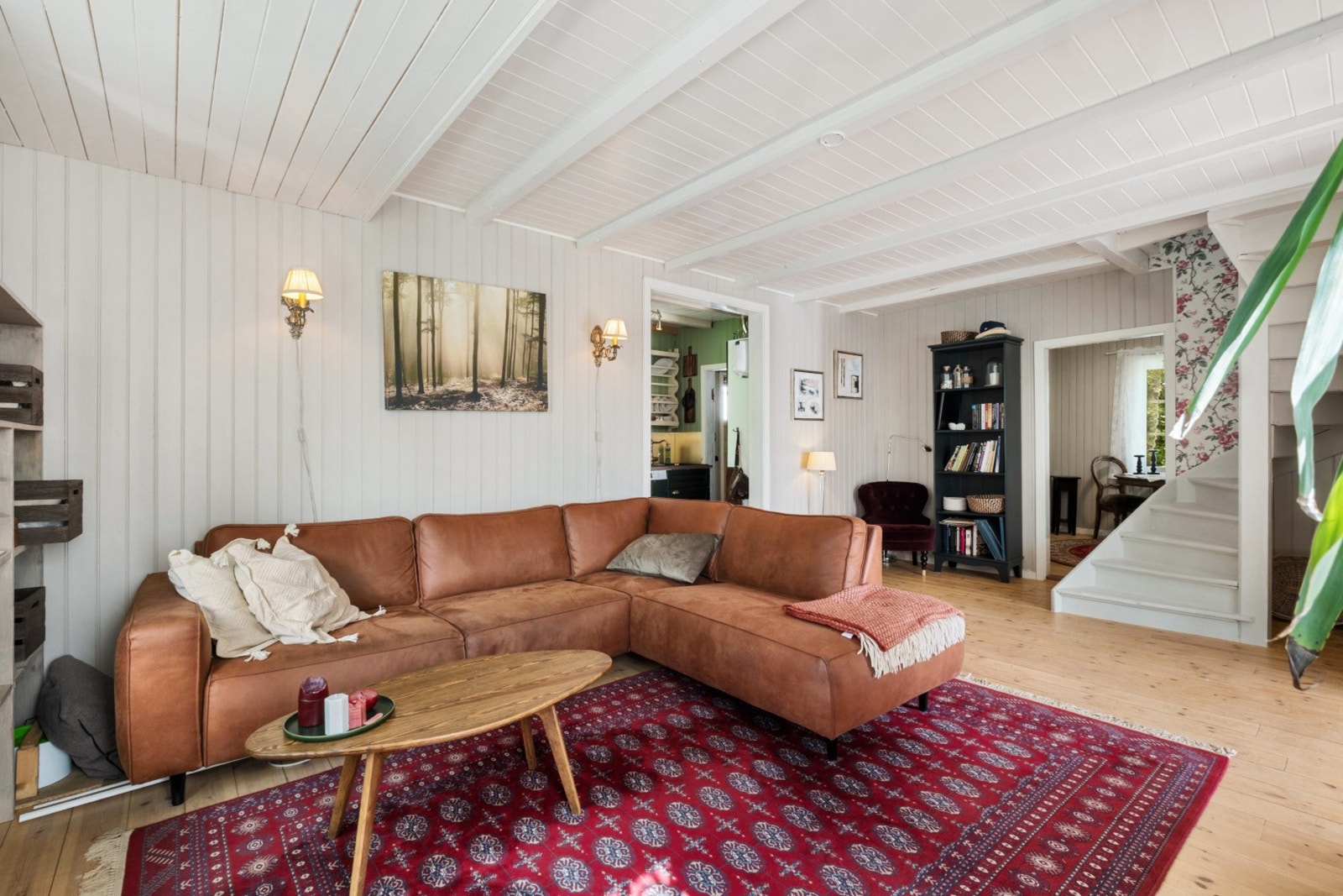 Overflatene i stuen består av trepanel på vegger og i himling. Galleribilde