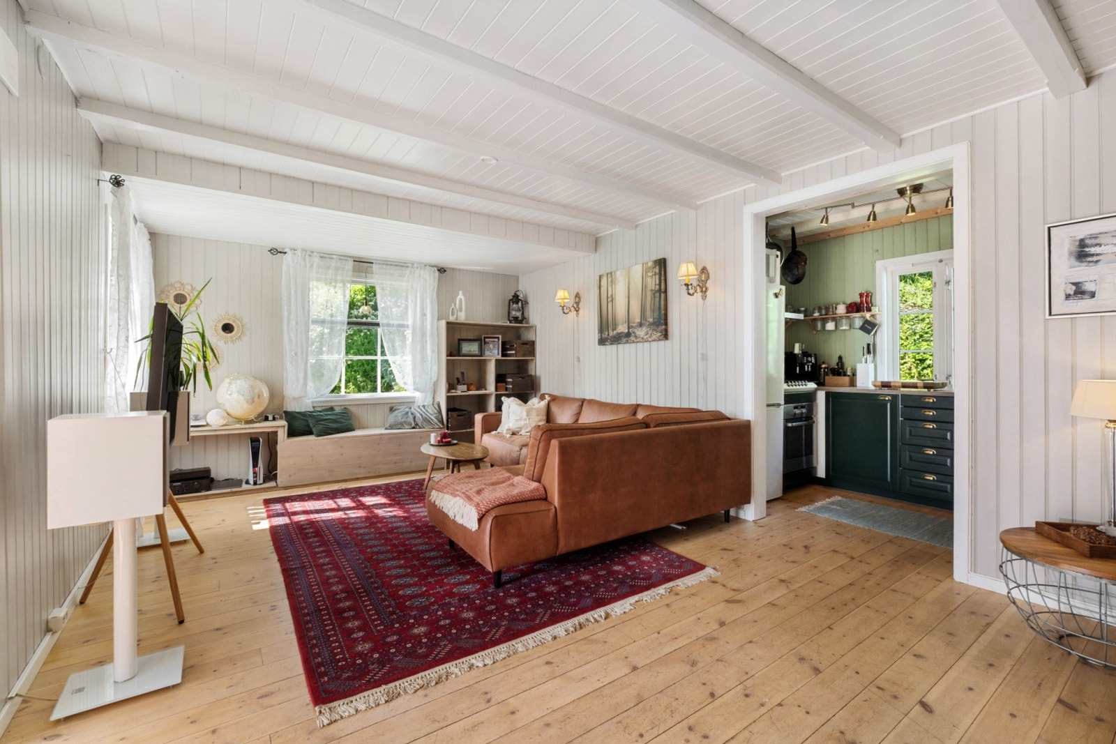 Stuen har gjennomgående furugulv og en åpen løsning mot kjøkkenet. Galleribilde