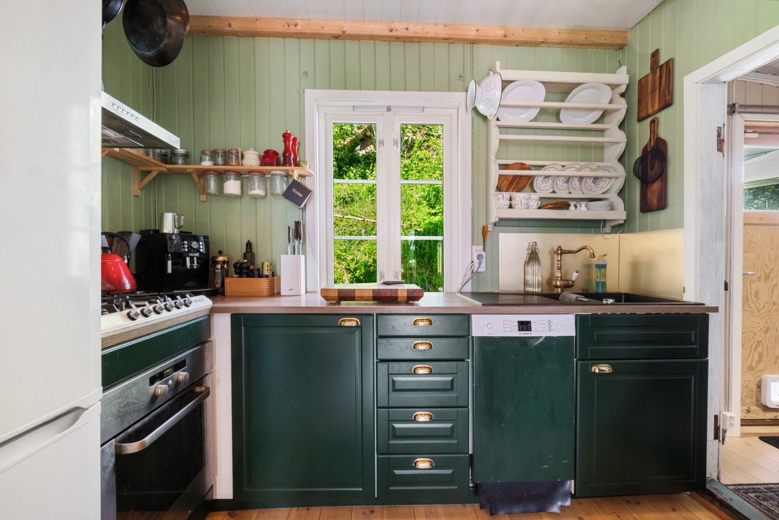 Kjøkkeninnredning med malte, profilerte fronter og benkeplate med nedfelt servant. Galleribilde